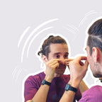 Person placing nasal strip in front of mirror on a light gray background
