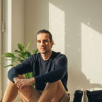 Man sitting indoors with a plant and sunlight casting shadows on the wall, nose strip NZ, airflow improved